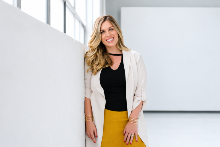 How Joanna Griffiths Built Knix Around Listening to Women Joanna Griffiths, founder of Knix, wearing a white blazer and yellow skirt beside a window.